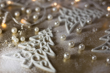Background for winter celebrations with Christmas tree ornaments, pearls and snow.