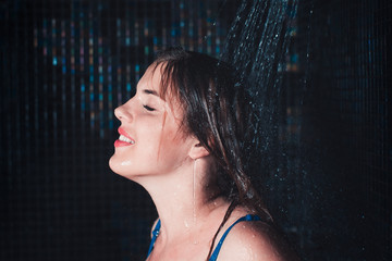 Young woman with waterproof makeup taking shower