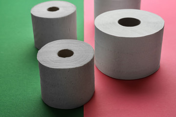 Rolls of toilet paper on color background