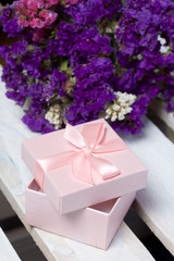 Wrapping presents. Gift boxes. Next is a bouquet of autumn dried flowers. Against the background of a wooden box.