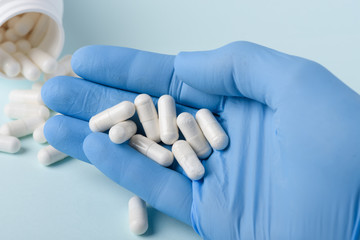 Pills medical drug capsules in doctor hand in glove