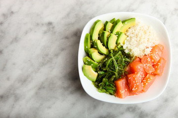 Hawaiian dish poke bowl on marble background. Top view. 