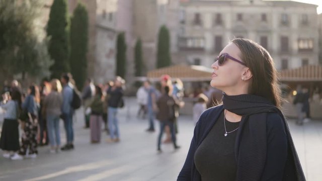 Business woman looking around and walking on city square, tourism concept.