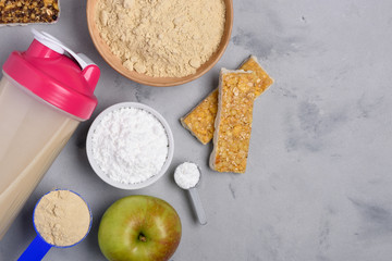 Sport nutrition with vegetarian protein powder for cocktail and creatine scoop on concrete background top view flat lay