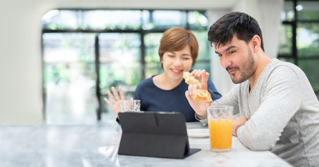 Young couple waving hands and making video call.
