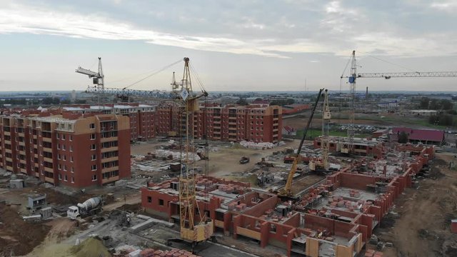 4k Aerial view of the city. Construction of residential buildings. Tower cranes working at a construction site