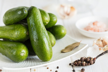 Ingredients for cooking pickled cucumbers on white background.