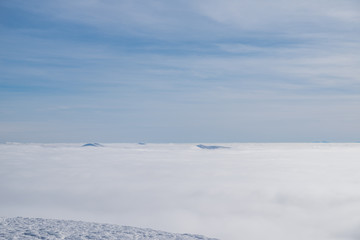 Fototapeta na wymiar Above white heavy clouds. Panorama of cloudscape from the top of the mountain.