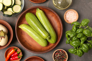 Composition with various fresh vegetables and spices on grey background