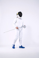 Fencer athlete wearing mask and white fencing costume and holding the sword, . Isolated on white background