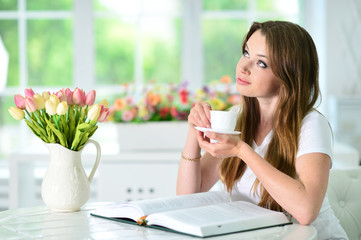 Beautiful young woman sitting with opened book