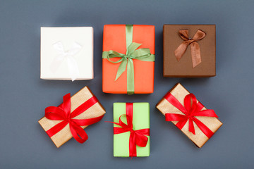 Gift boxes with red and green ribbons on gray background.