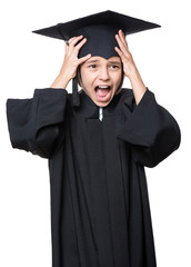 Portrait of shocked little girl wearing black graduation gown - isolated on white background. Child back to school and educational concept.