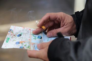 hands hold a map and a cigarette, Tourist smoking in Barcelona