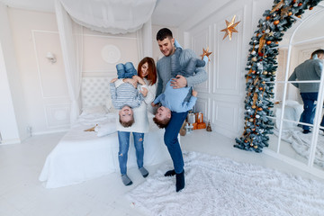A family of four hugging in front of the christmas tree. New year's eve. Cozy holiday at the fir-tree. love, happiness and big family concept