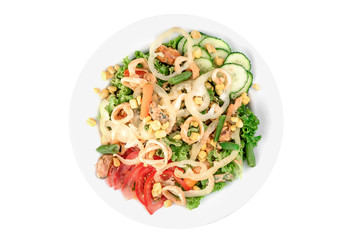 Salad with mussels, squid, bell pepper, tomatoes, corn, cucumbers and asparagus in a white plate isolated on white background. top view. flat lay
