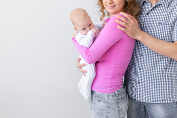 Family, childhood and parenthood concept - close up of father, mother holding cute baby over white background with copy space