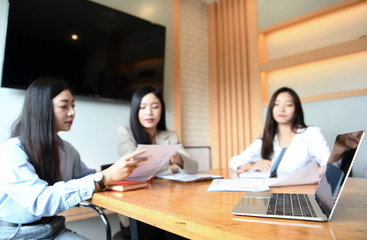 Three working women are meeting in office.