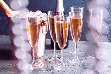 Champagne bottle in bucket with ice and glasses of champagne