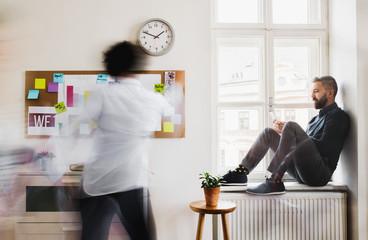 Young businesspeople in a modern office, having break. Motion blur.