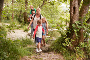 Fototapeta premium Family Hiking Along Path By River In UK Lake District