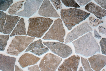 The stone floor is decorated with a variety of geometric mosaic, blue, red, white, black tile. Abstract geometric chaotic pattern.