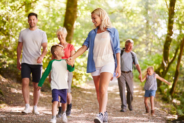 Multi Generation Family Enjoying Walk Along Woodland Path Together