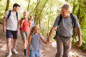 Multi Generation Family Enjoying Walk Along Woodland Path Together