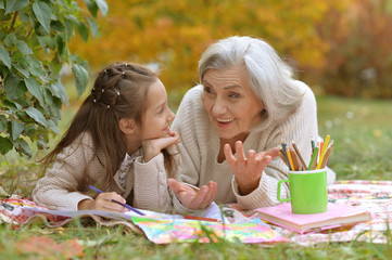 Portrait of girl with her grandmother drawing