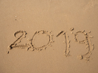 Sand written numbers on beach