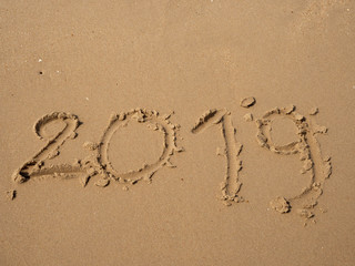 Sand written numbers on beach