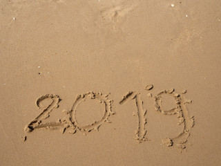 Sand written numbers on beach