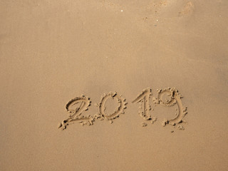 Sand written numbers on beach