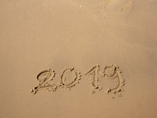 Sand written numbers on beach
