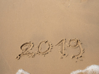 Sand written numbers on beach