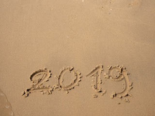 Sand written numbers on beach