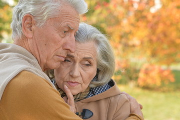 Portrait of sad senior couple in autumn park