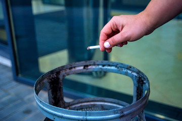 Cigarette in wonam's hand over garbage bin