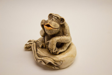 Netsuke monkey with a bag. On a white background