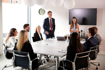 Group Of Young Businessmen And Businesswomen Meeting Around Table At Graduate Recruitment...
