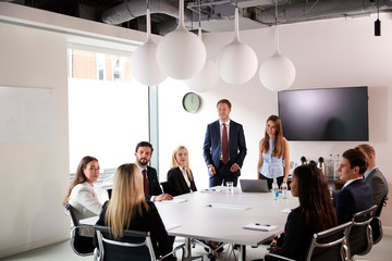Group Of Young Businessmen And Businesswomen Meeting Around Table At Graduate Recruitment...