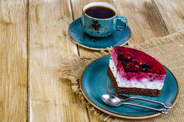 Piece of jelly mousse cake with fruit, cup of tea
