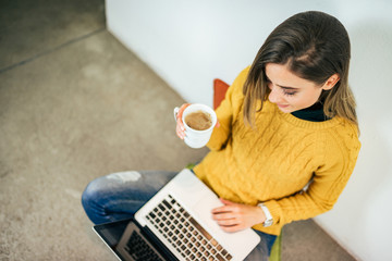 Young woman working on laptop. Top view.