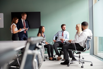 Group Having Discussion At Graduate Recruitment Assessment Day Whilst Being Observed By Recruitment...