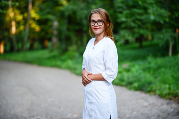 Good doctor. a young girl who is a doctor stands outside, hands
