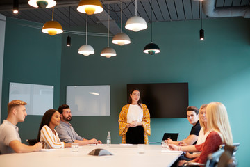 Businesswoman Addressing Group Of Candidates Meeting Around Table At Graduate Recruitment...