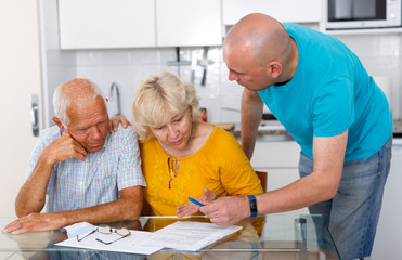 Unhappy aged couple signing financial agreement with social worker