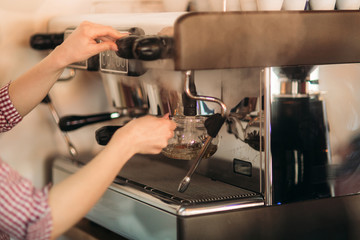 Barista using a coffee machine in cafe