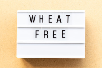 Light box with word wheat free on wood background