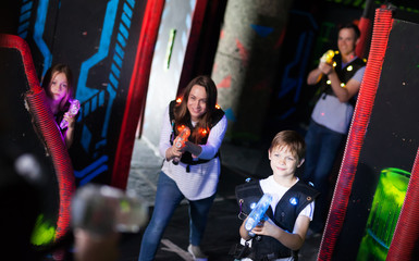 Obraz na płótnie Canvas Parents and children playing laser tag